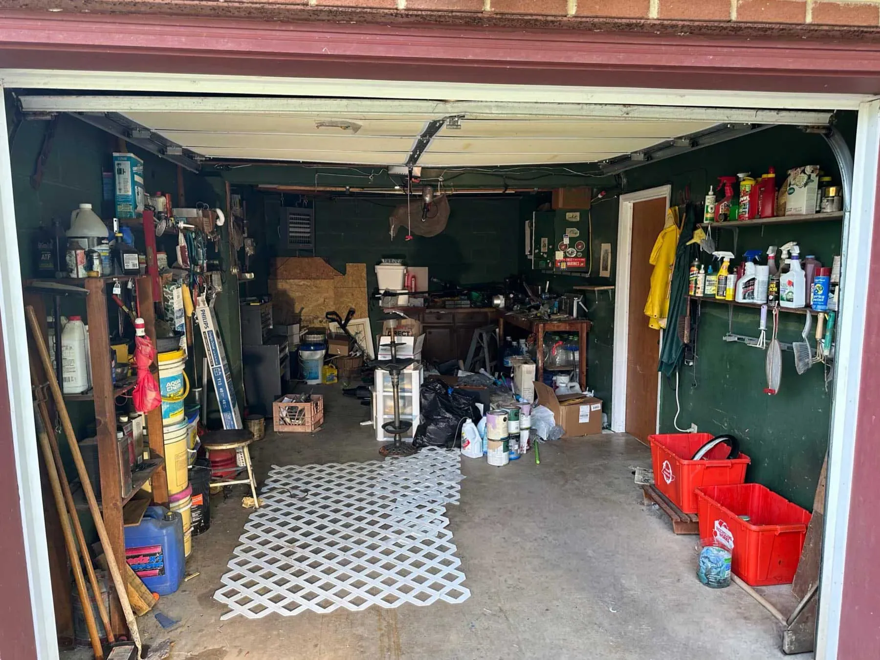 Residential garage containing tools, shelving, containers and other stored items before a real estate cleanout