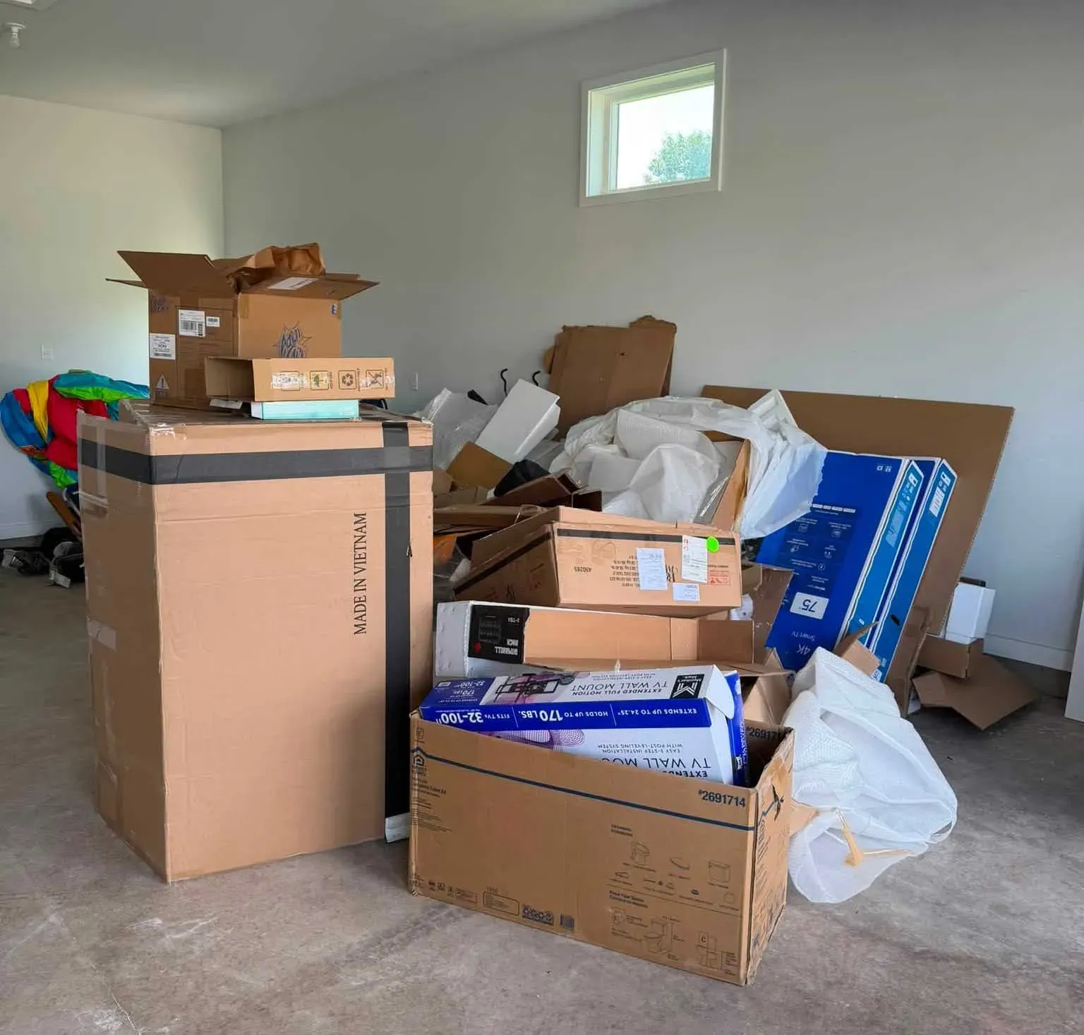 Cardboard boxes and packing materials collected for removal inside a basement